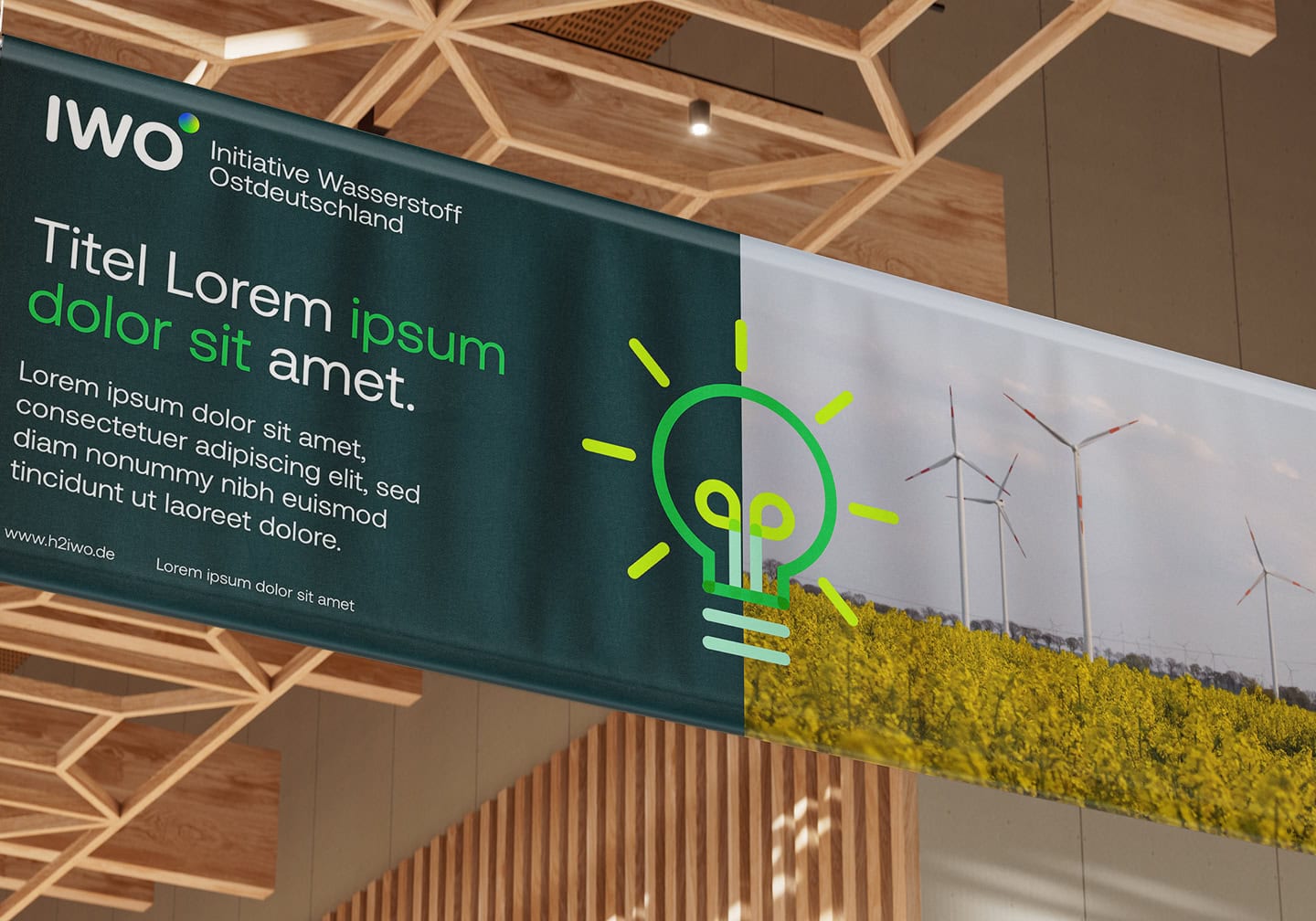 Messe-Banner der Initiative Wasserstoff Ostdeutschland mit Logo, Glühbirnen-Symbol und Windkraftlandschaft.
